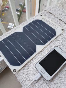 Small solar panels powering a plugged-in cell phone