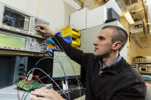 A young man works on an electronic device.