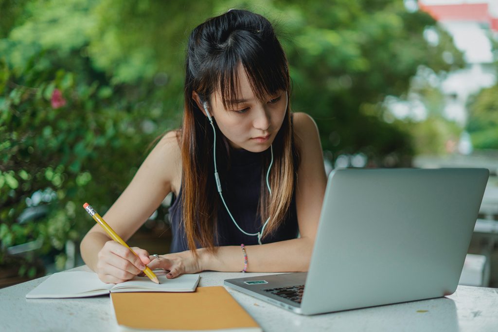 Female studying with laptop and notebook