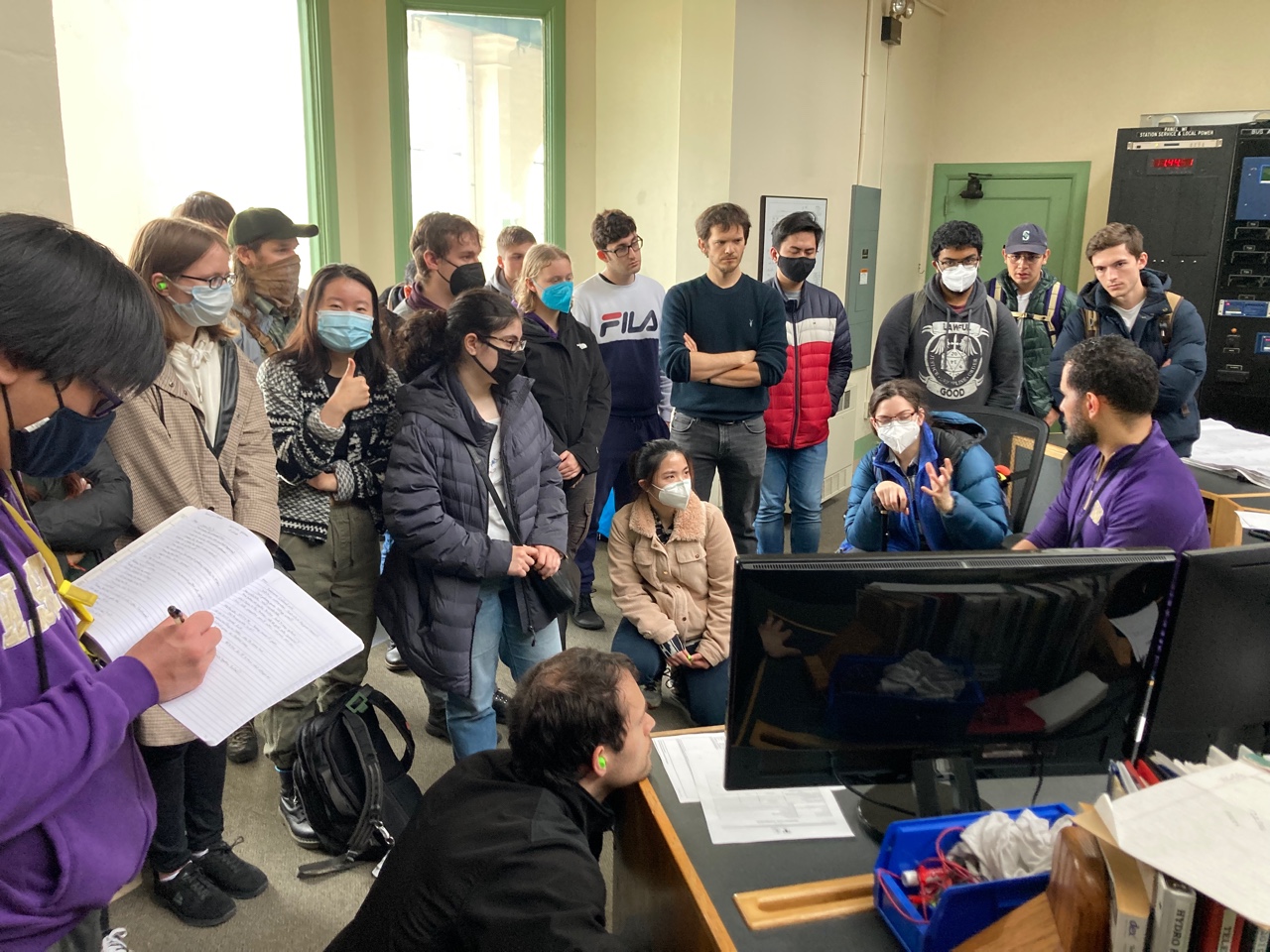 Ozan Ferrin explains the components of the dam as students listen and take notes