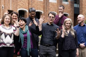 2022 UW ECE Award nominees and recipients in a group, standing outside the UW ECE building, making the "W" in "UW" with their hands