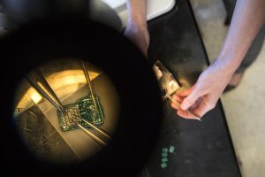 View through microscope of circuitry being adjusted