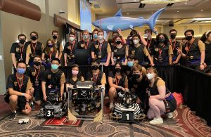 Group of students gathered around three robots