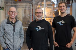 From left to right: UW ECE alumni Steve Zwaller, UW ECE Research Professor Emeritus Brian Nelson, UW ECE Professional Master's Program student Daniel Garratt, standing next to each other in front of equipment at Zap Energy