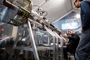 Two male employees working on the Zap Energy nuclear reactor prototype