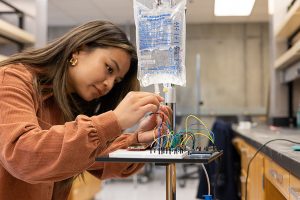 Woman adjusting wires connected to an IV bag