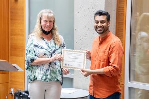 UW ECE Professor Denise Wilson presenting UW ECE Assistant Teaching Professor Mahmood Hameed with an award certificate