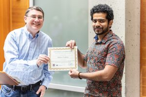 UW ECE Associate Professor Matt Reynolds present the Vikram Jandhyala and Suja Vaidyanathan Endowed Innovation Award certificate to Mathew Varghese.