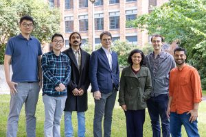 Photo of Eric Klavins standing outside the UW ECE building with some of the 2023 UW ECE award recipients