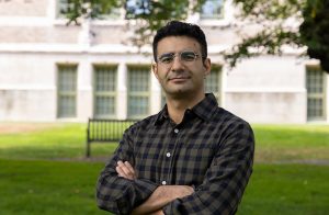 UW Assistant Professor Sajjad Moazeni standing with his arms folded, outdoors in the UW Quad