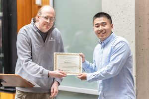 UW ECE and Allen School Professor Joshua Li presenting Bingzhao Li with a certificate