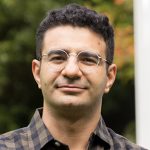 UW ECE Assistant Professor Sajjad Moazeni stands next to columns in Sylvan Grove on the UW campus.