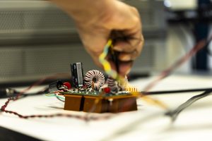 A closeup of a student's hand adjusting a coil on the spiral coil prototype