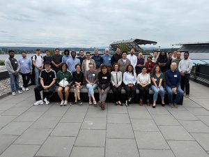 Photo of a large group of people together on the rooftop deck of the Gates Center