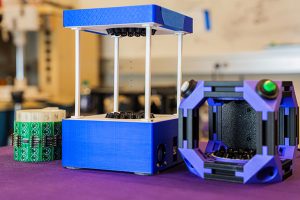 Three acoustic levitation prototypes sitting side by side on a table.