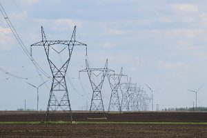 Photo of power poles and electrical lines in a field.